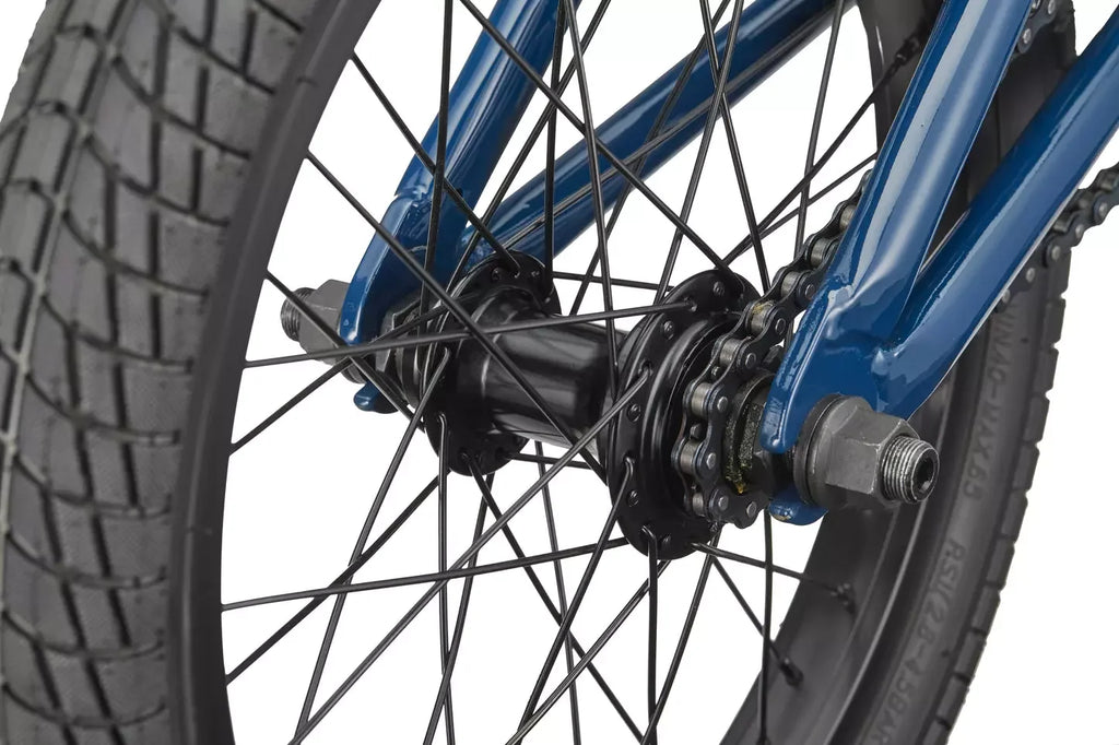 Détail de la roue arrière et de la chaîne d'un vélo BMX bleu.