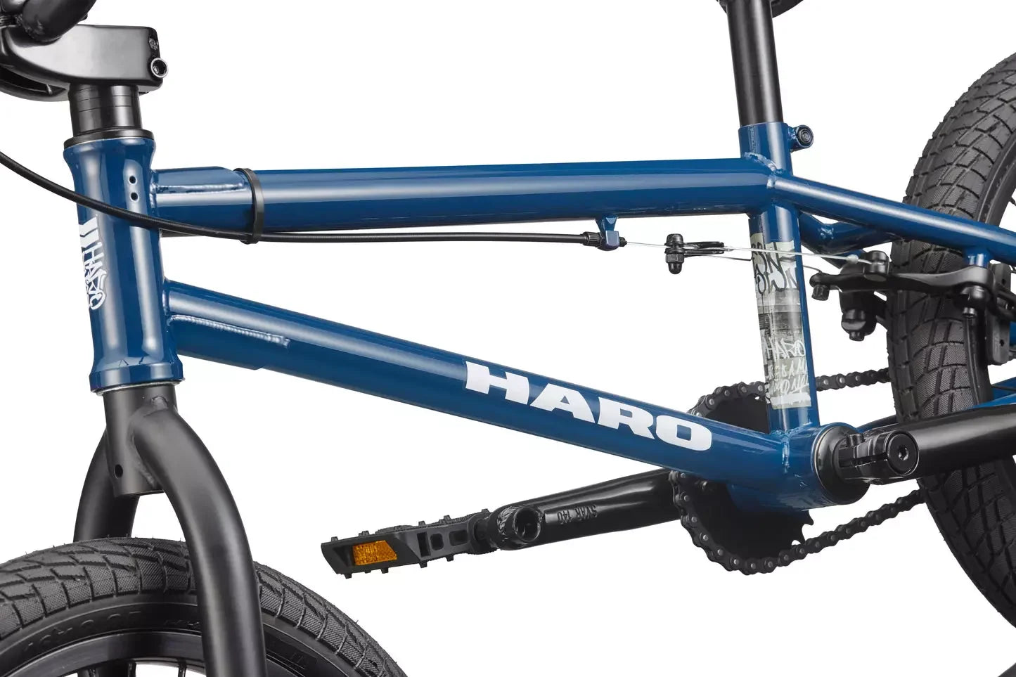 Cadre de BMX bleu Haro avec pédales noires et chaîne de transmission.