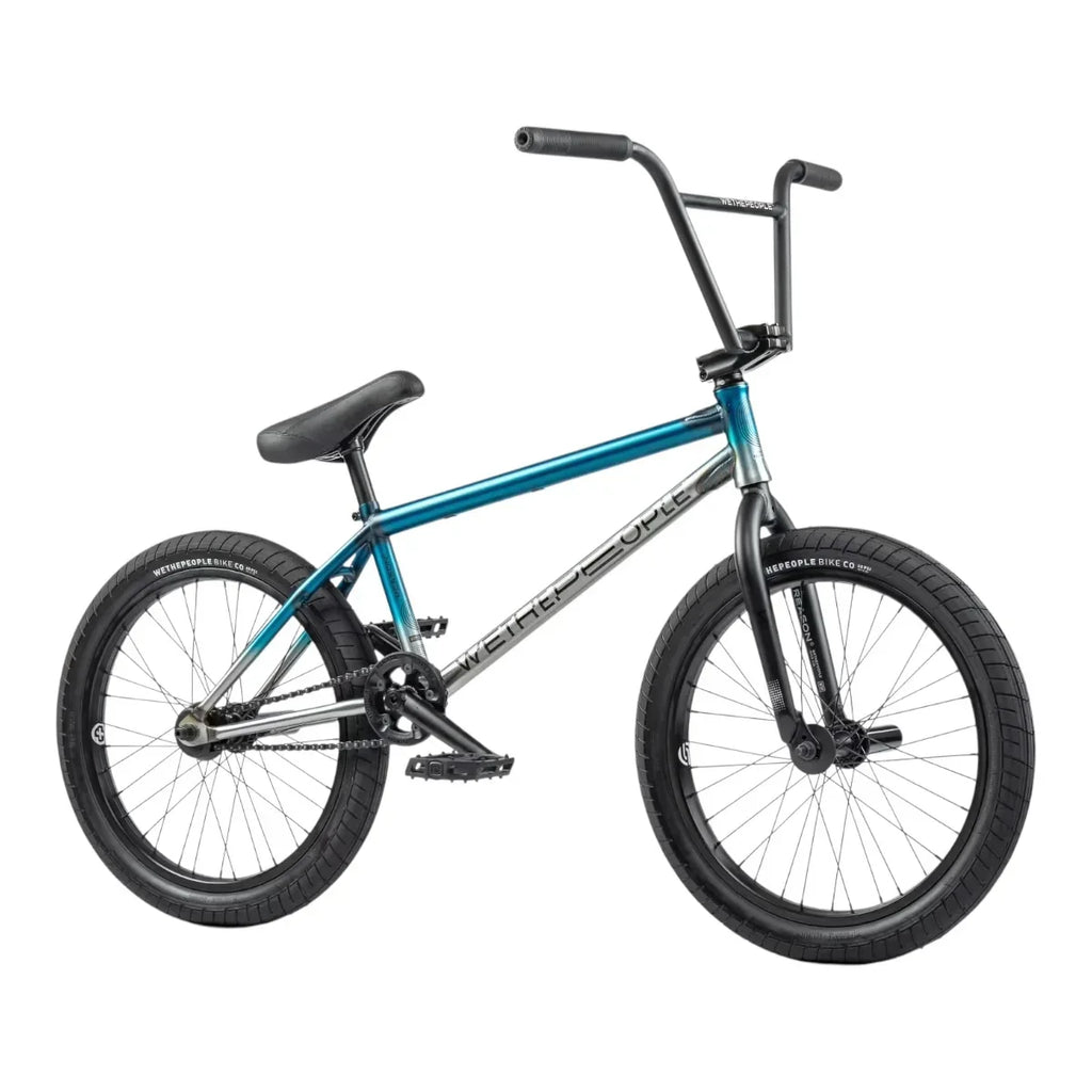 Vélo BMX Wethepeople avec cadre bleu métallisé et composants noirs, idéal pour le freestyle et les tricks.