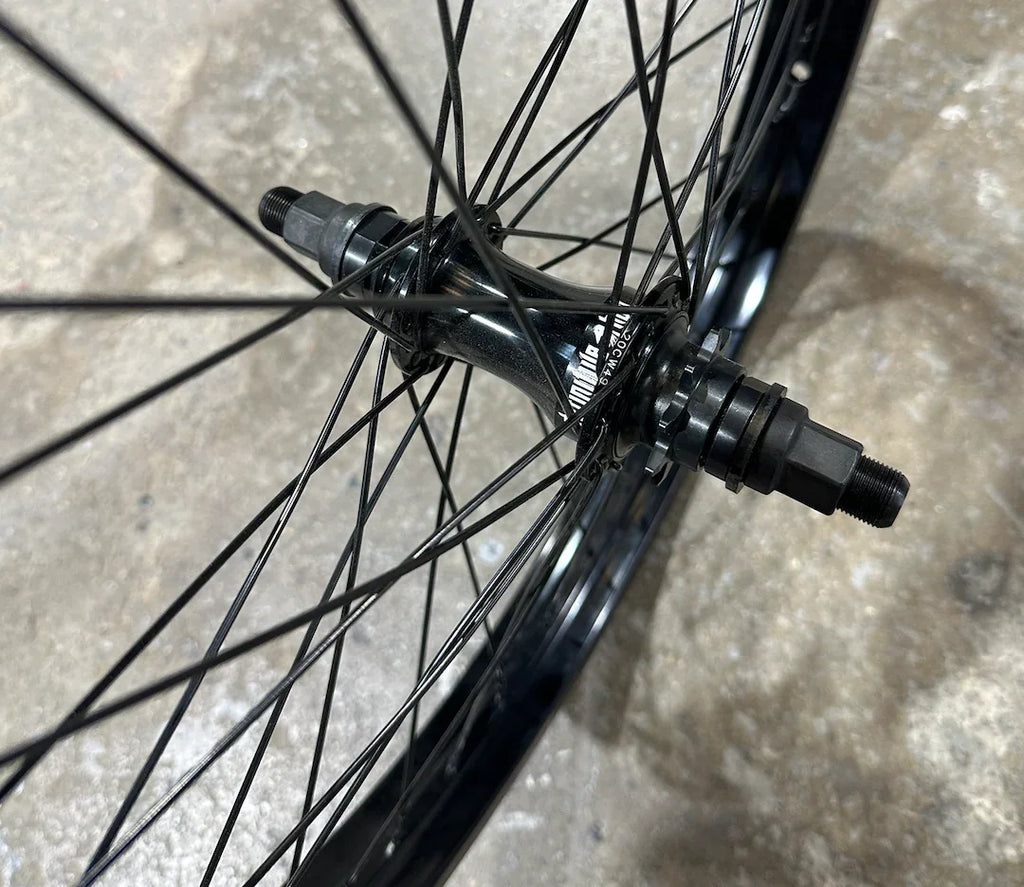 Roue BMX noire avec moyeu et rayons robustes pour performance et durabilité