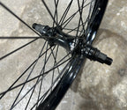 Roue BMX noire avec moyeu et rayons robustes pour performance et durabilité