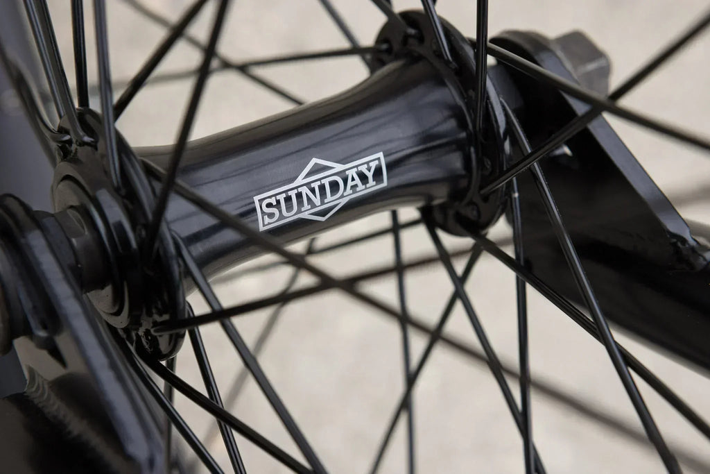 Gros plan du moyeu de roue BMX noir avec le logo Sunday