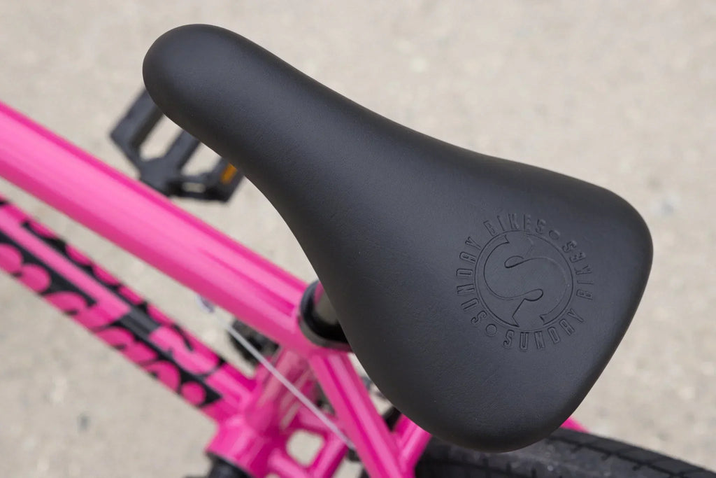 Selle de vélo BMX noire avec logo Sunday sur cadre rose vif
