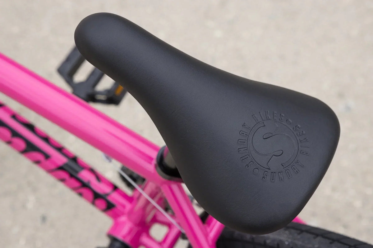 Selle de vélo BMX noire avec logo Sunday sur cadre rose vif