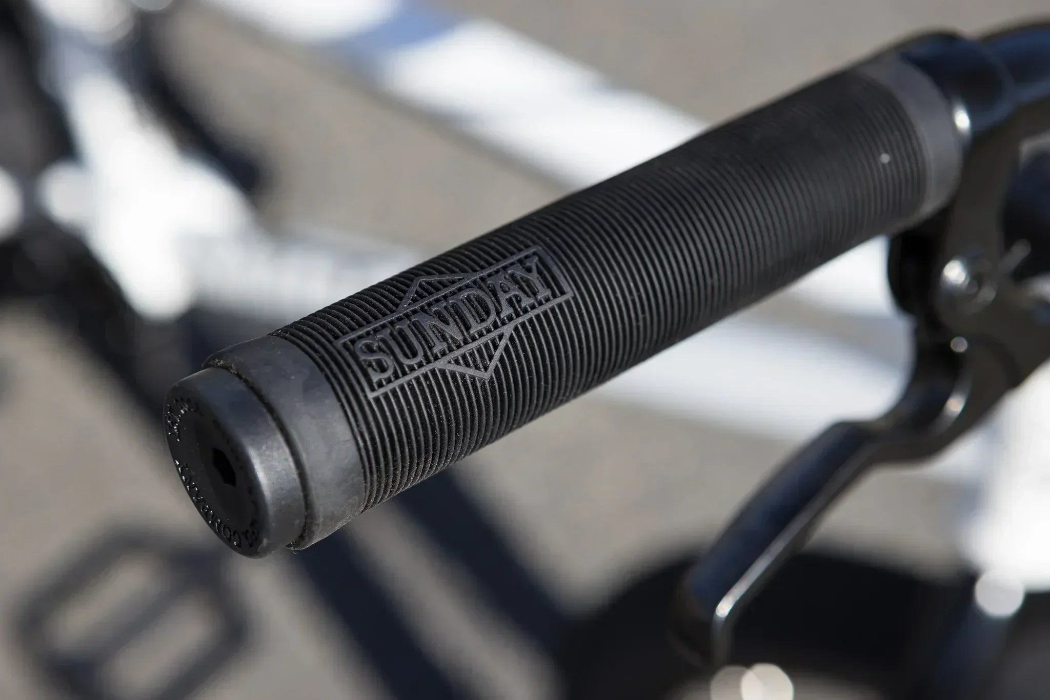 Gros plan d'une poignée de guidon BMX noire texturée de marque Sunday