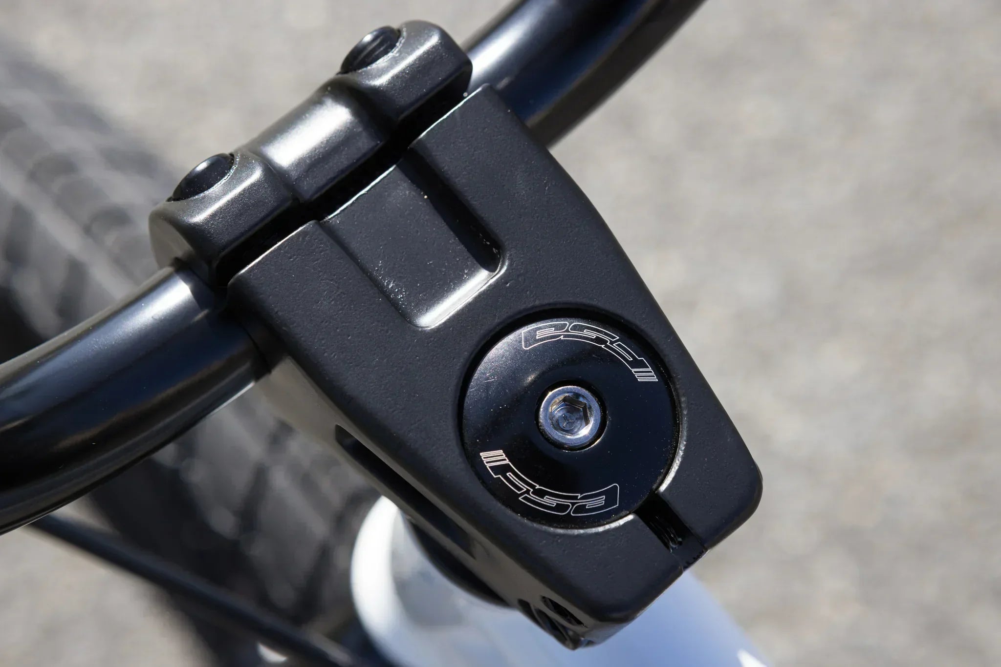 Gros plan d'une potence de BMX noire avec vis de fixation