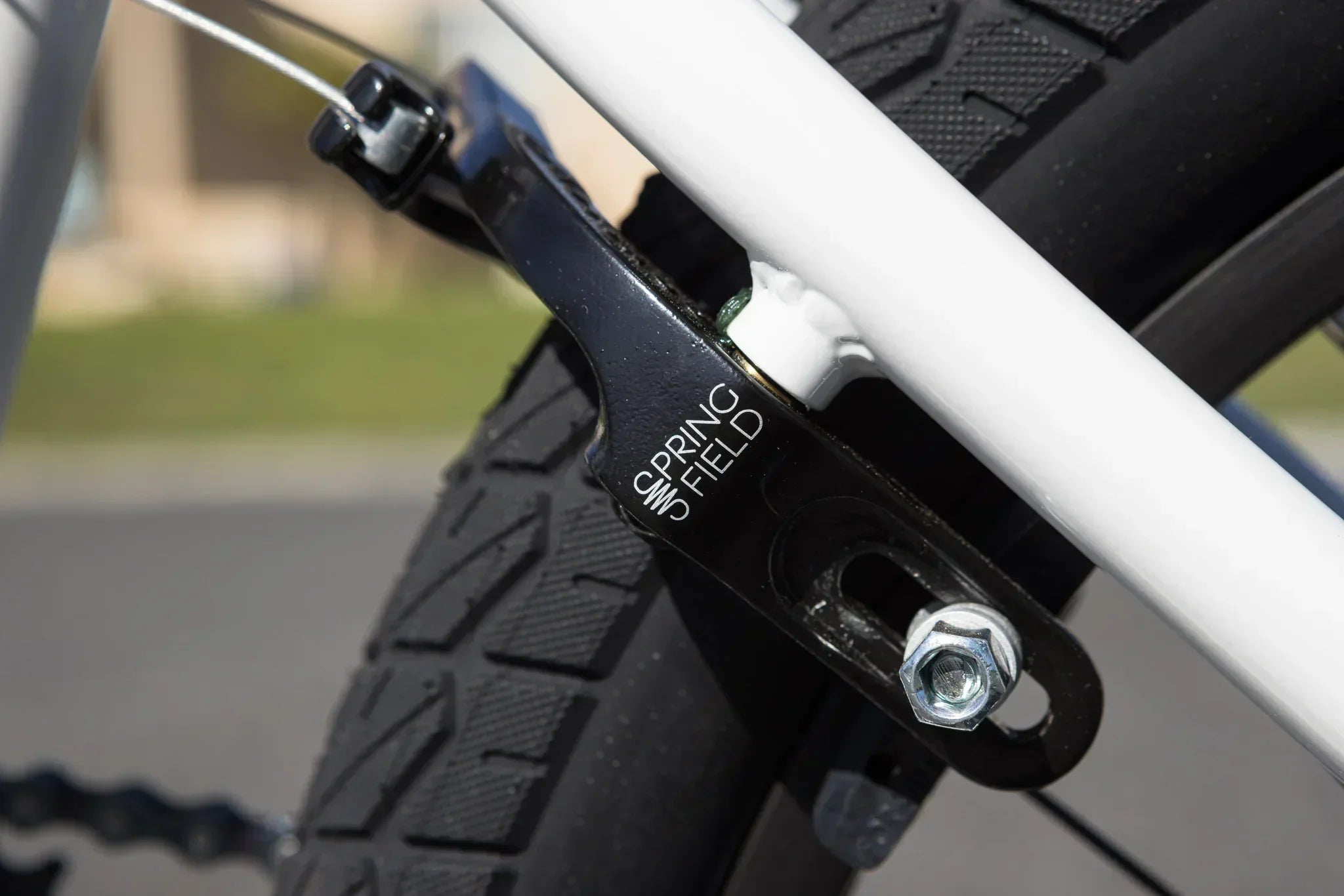 Gros plan d'un support de frein noir Springfield sur un cadre de vélo blanc.