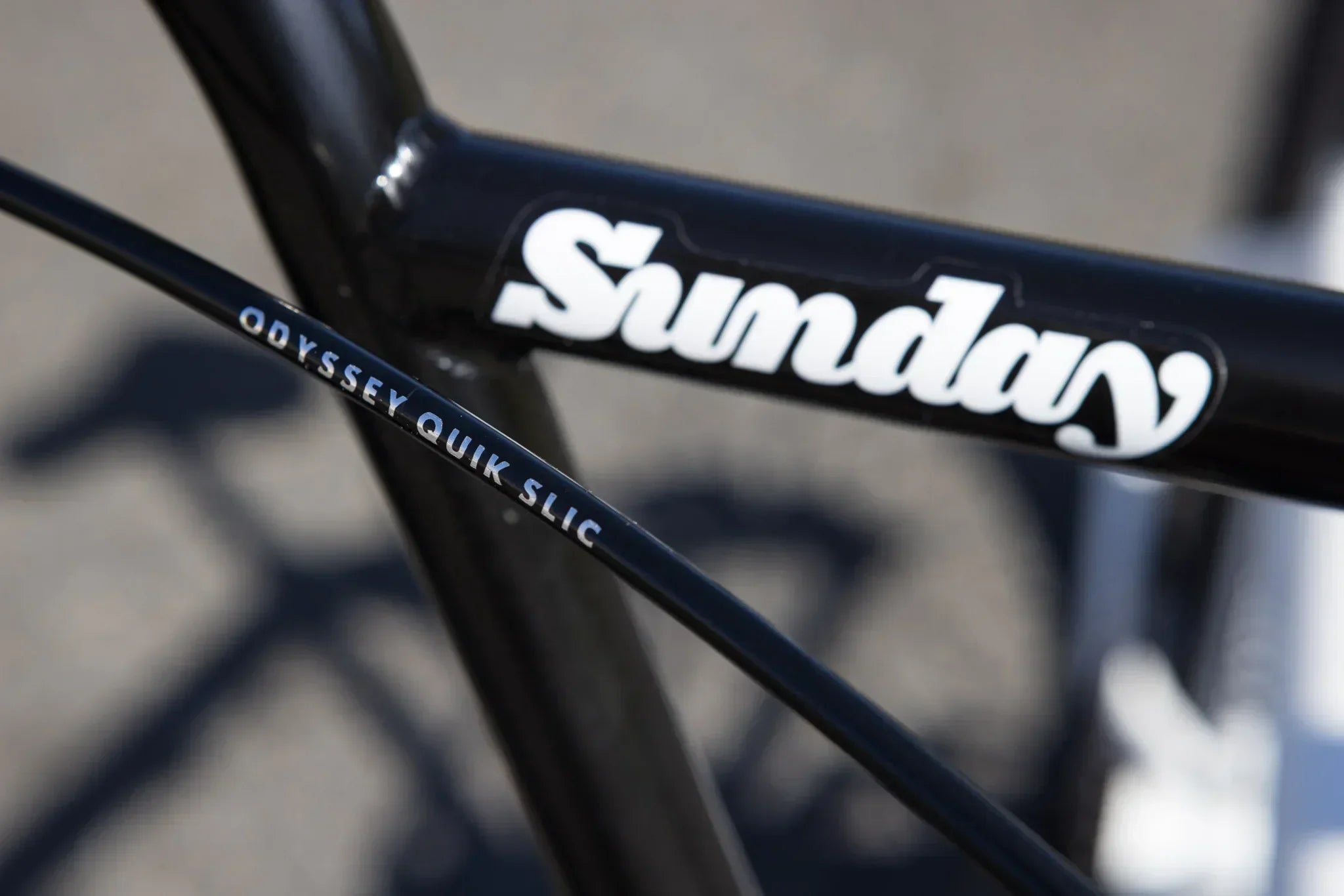Gros plan d'un cadre de vélo BMX noir Sunday avec un câble Odyssey Quik Slic.