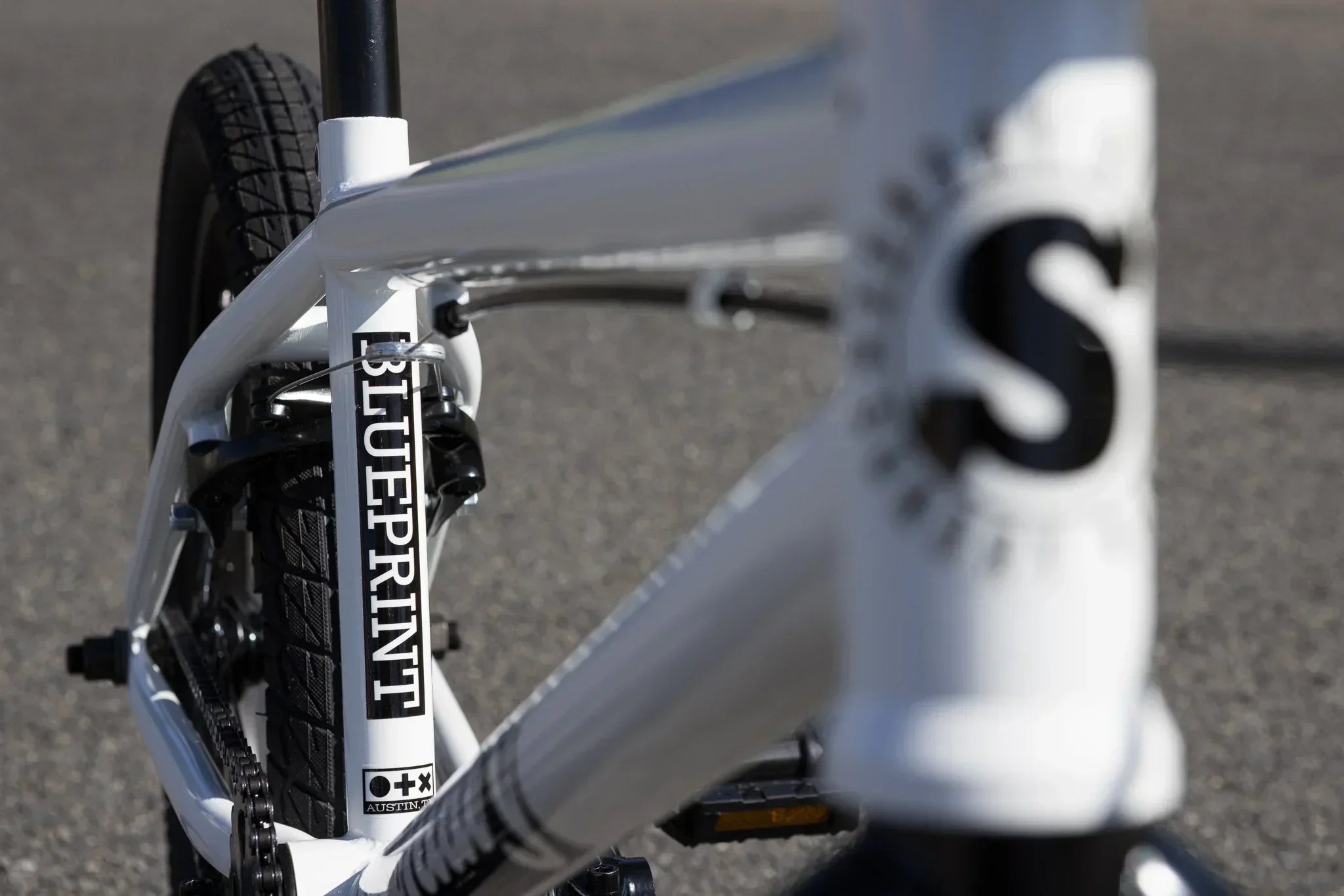 Détail du cadre blanc d'un vélo BMX avec le logo Blueprint