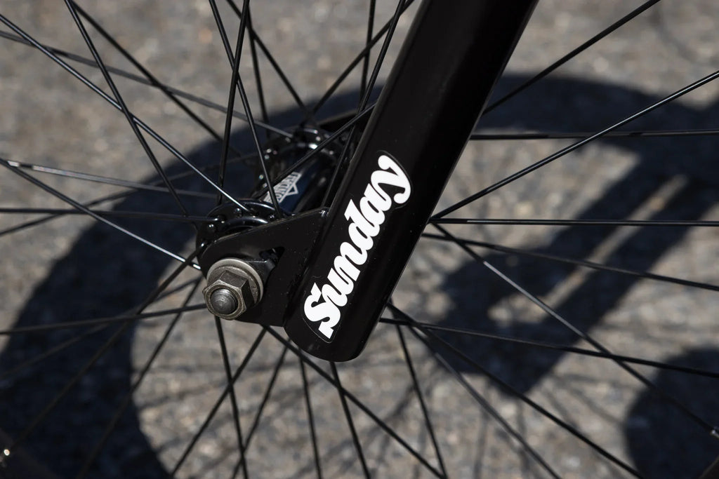 Gros plan du moyeu et de la fourche arrière noire d'un vélo BMX Sunday