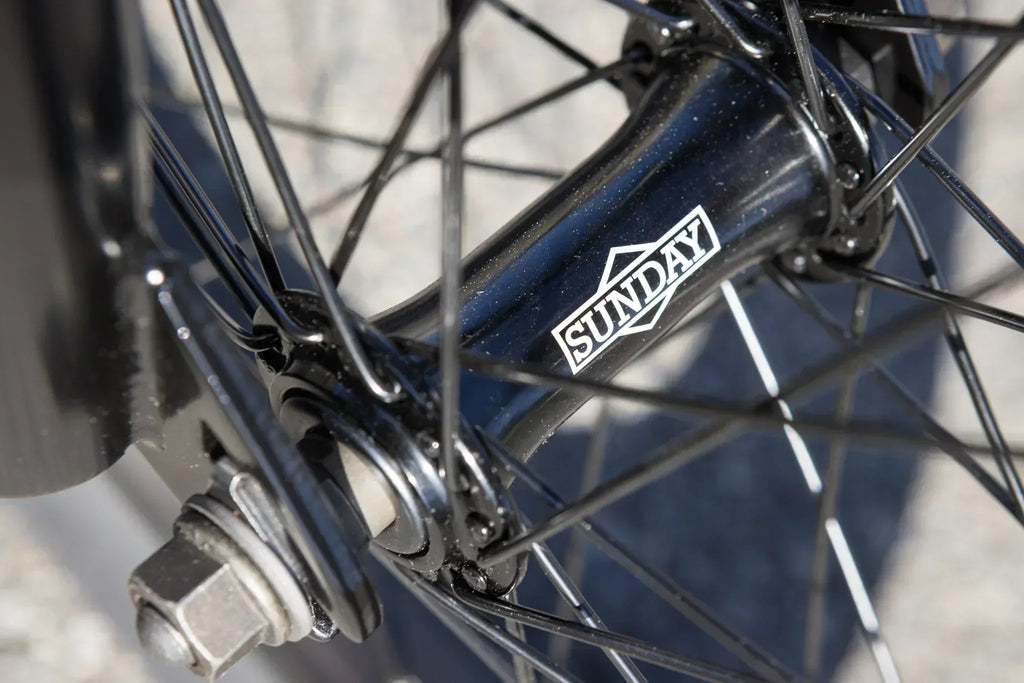 Gros plan du moyeu de roue de vélo BMX noir avec le logo Sunday