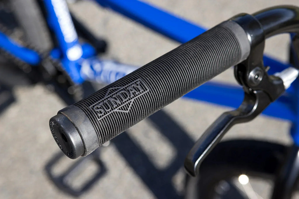 Gros plan d'une poignée de guidon BMX noire avec le logo Sunday