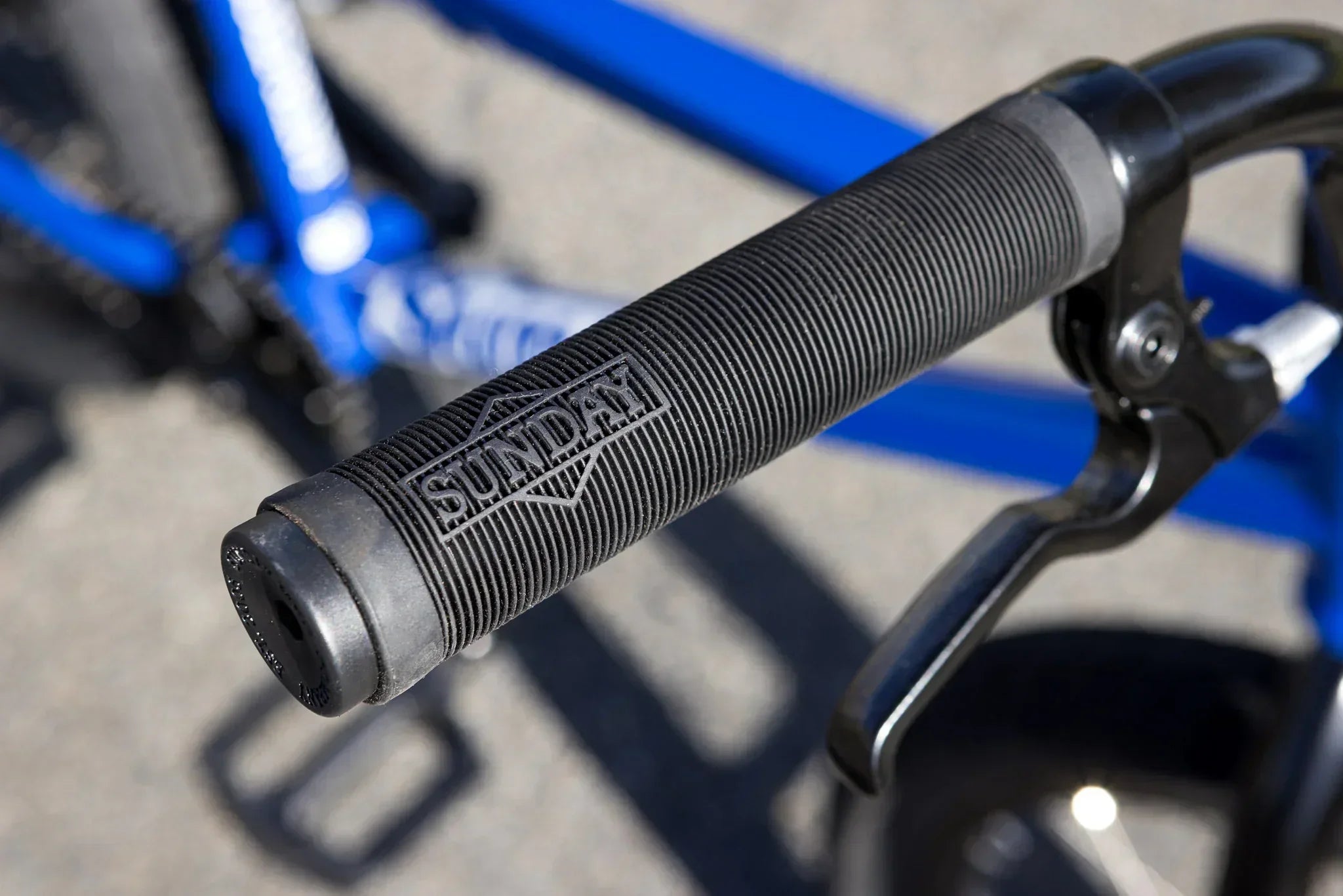 Gros plan d'une poignée de guidon BMX noire avec le logo Sunday