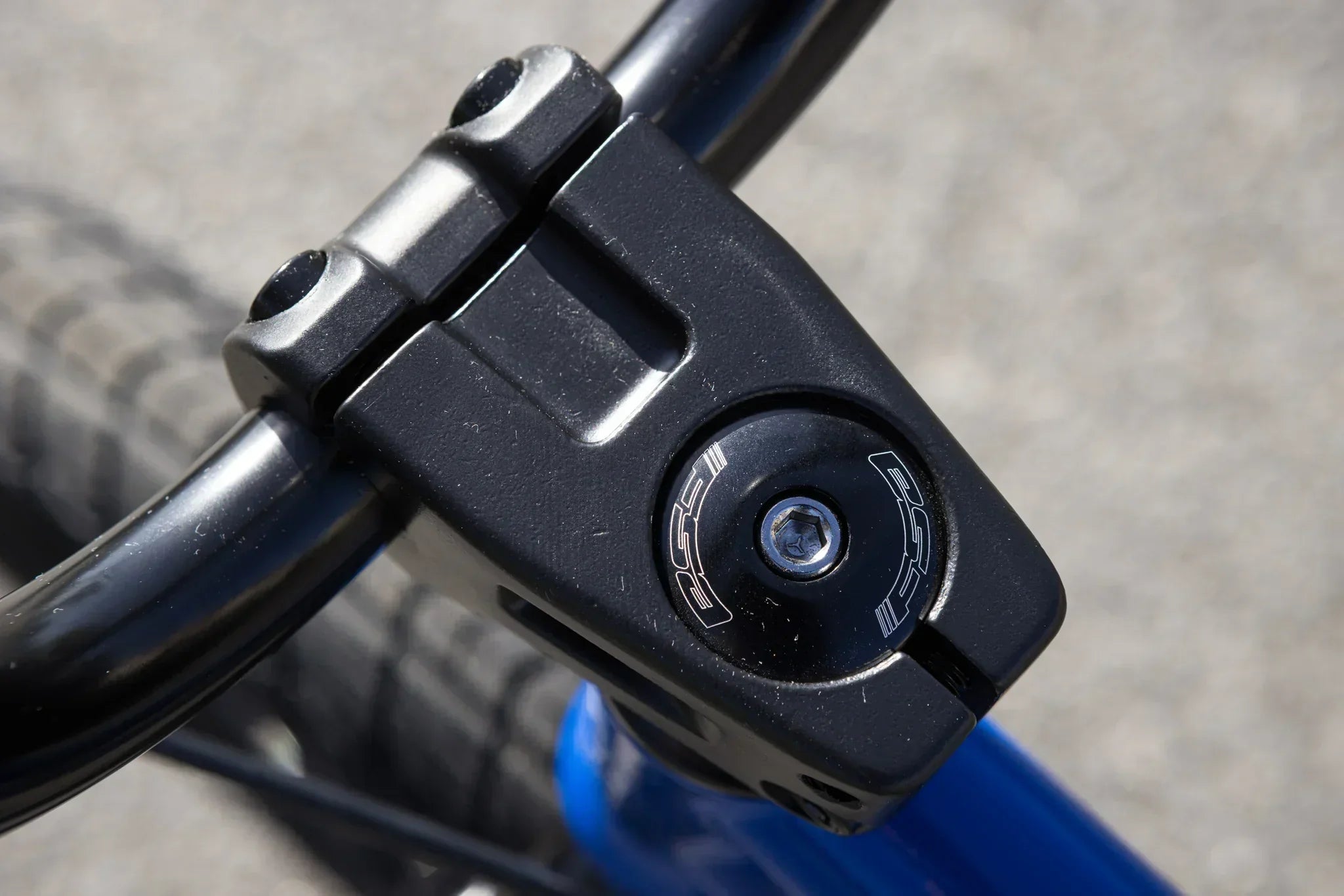 Gros plan d'une potence de BMX noire avec vis de fixation