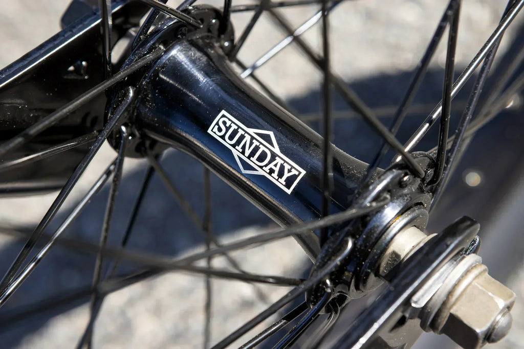 Gros plan d'un moyeu de roue BMX noir avec le logo Sunday blanc