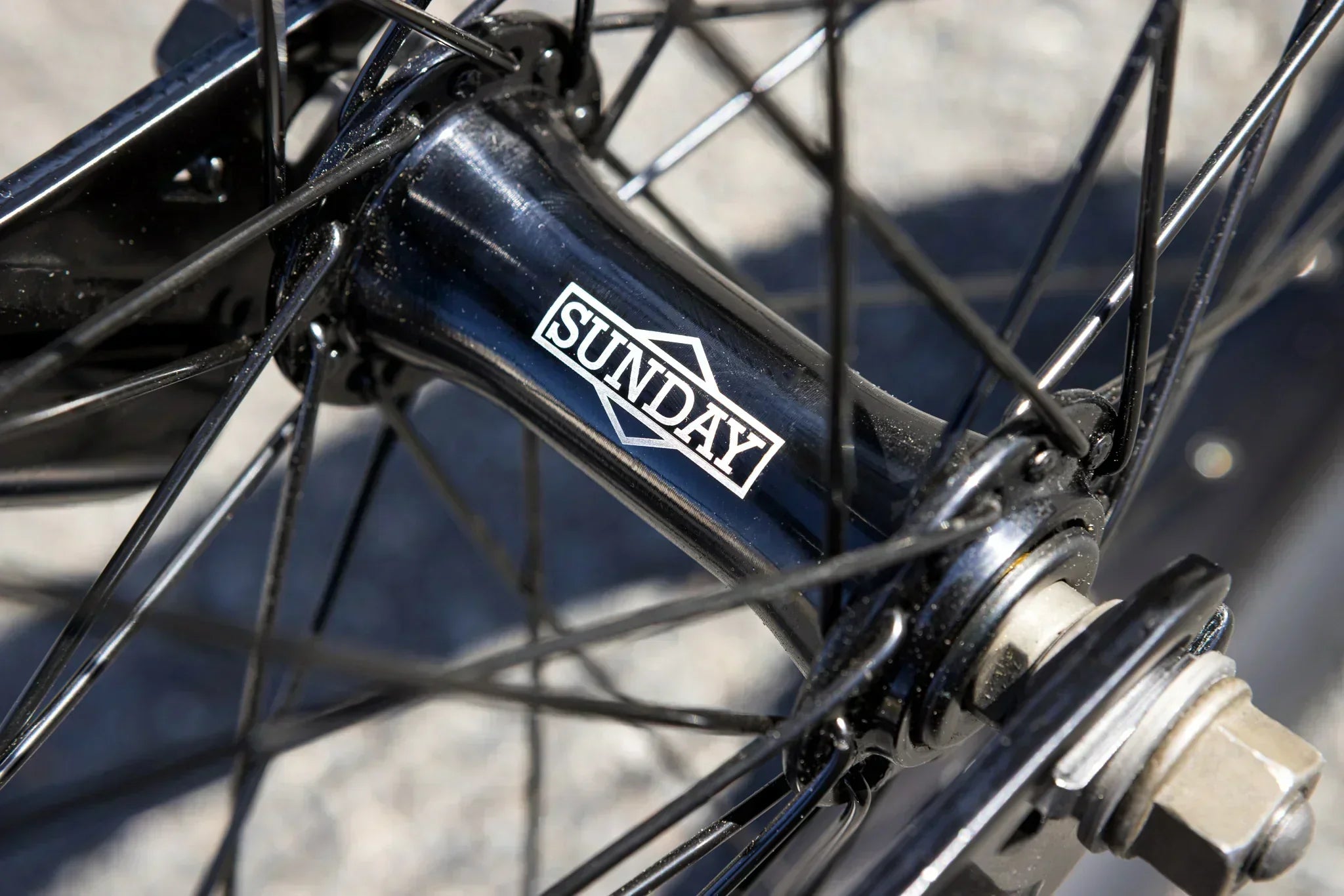 Gros plan d'un moyeu de roue BMX noir avec le logo Sunday blanc