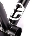 Close-up of matte black BMX bike frame with white logo and visible welds