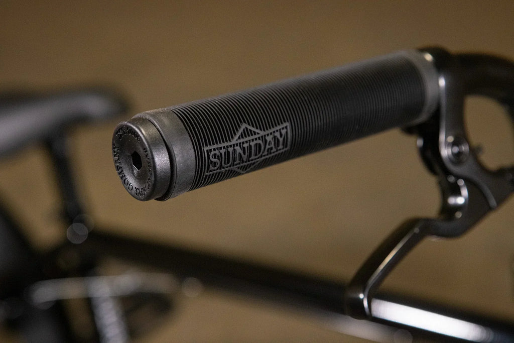 Gros plan d'une poignée de guidon BMX noire texturée de la marque Sunday.