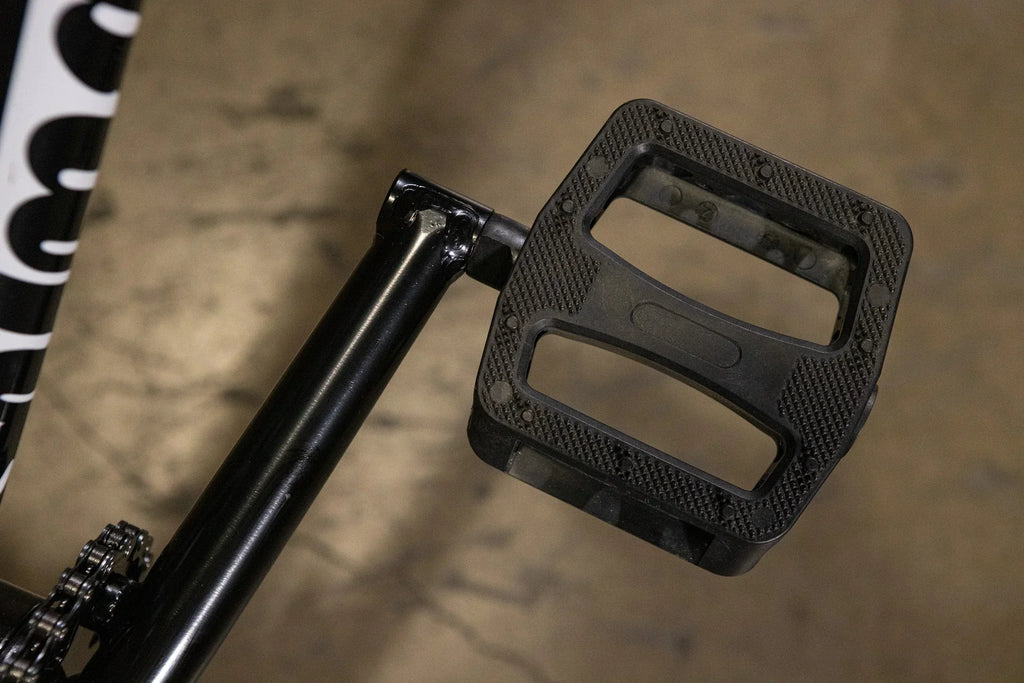 Gros plan d'une pédale de vélo BMX noire en nylon avec surface antidérapante