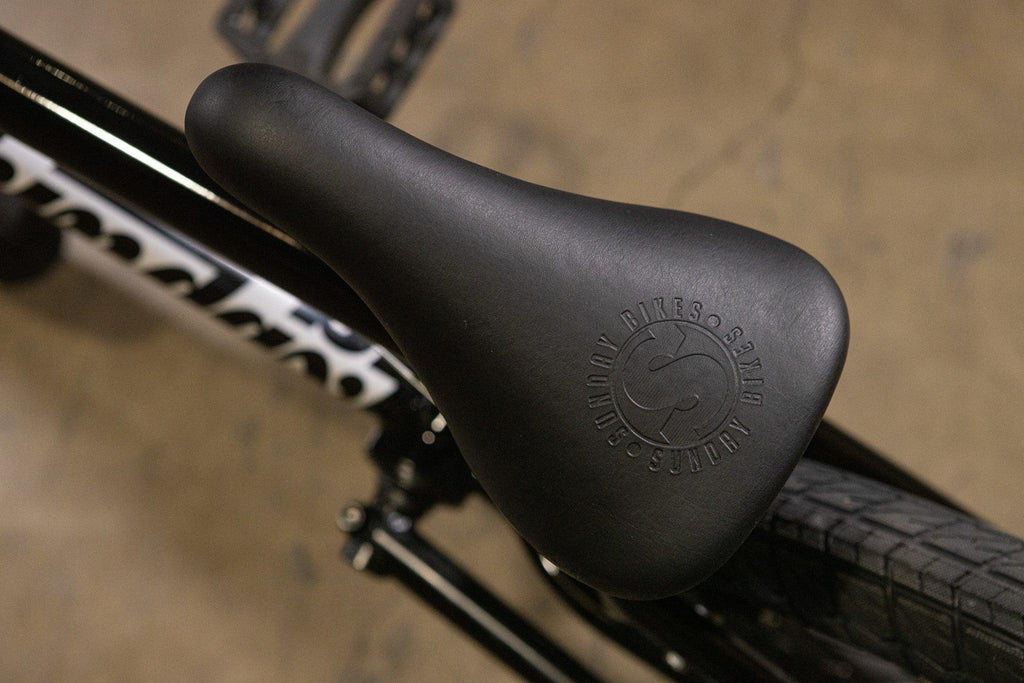 Gros plan d'une selle de vélo BMX noire avec logo embossé