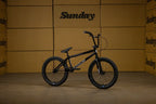 Vélo BMX Sunday noir sur fond de cartons de marque Sunday