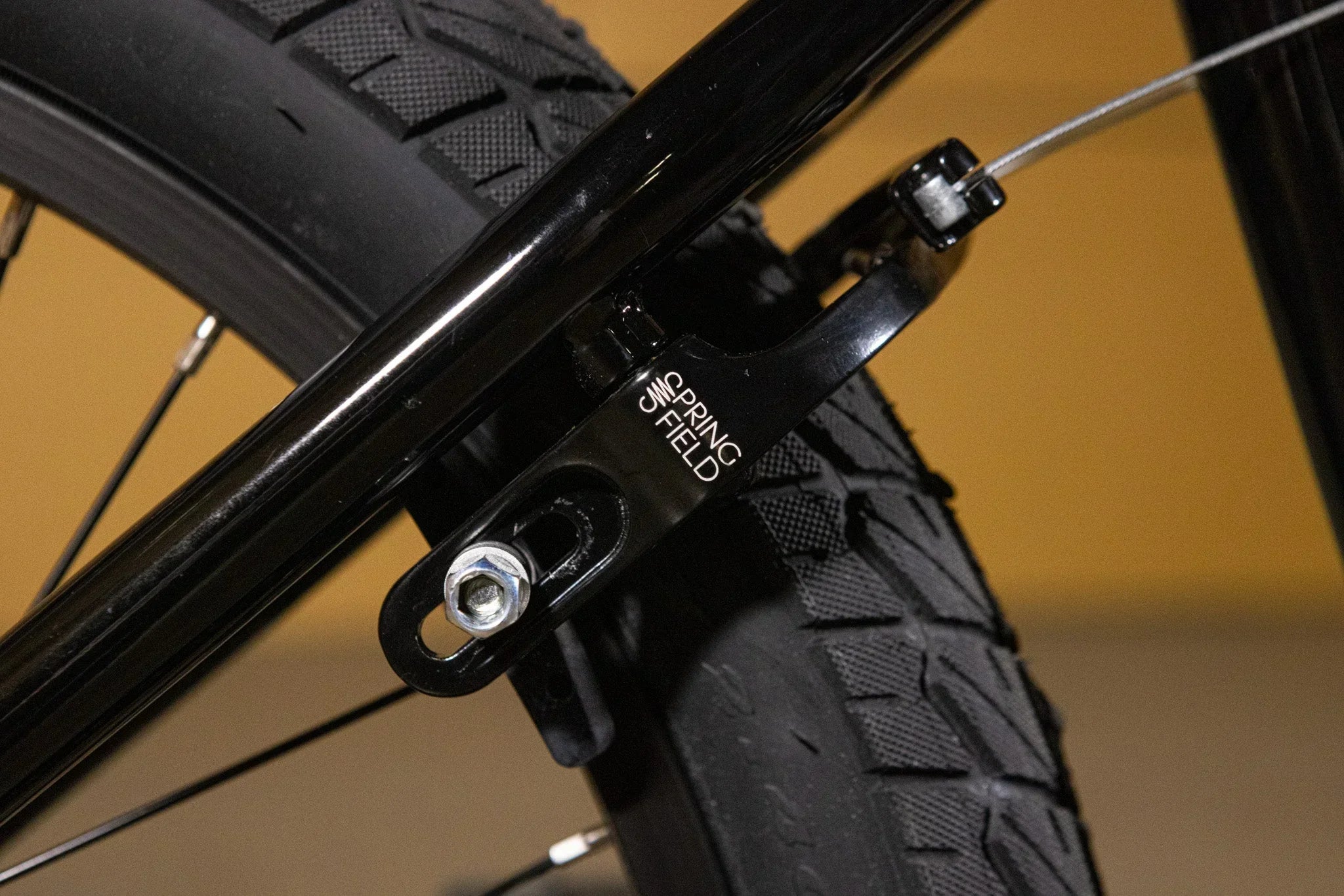 Gros plan d'un frein arrière Springfield noir monté sur un vélo BMX.