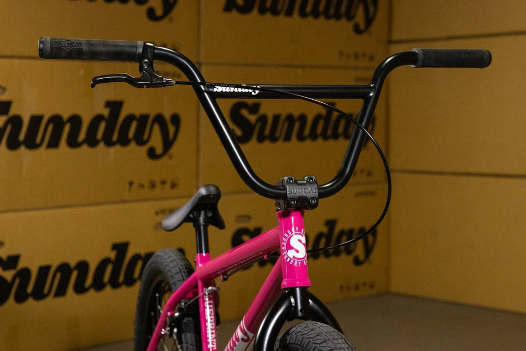 Gros plan du guidon et du cadre rose d'un vélo BMX Sunday