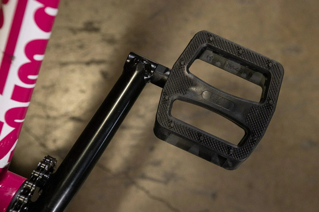Gros plan d'une pédale de vélo BMX noire en plastique robuste.