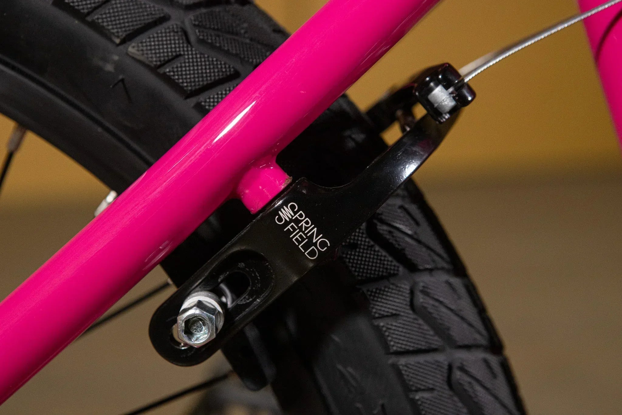 Gros plan d'un garde-boue arrière Springfield noir sur un cadre de vélo BMX rose vif.