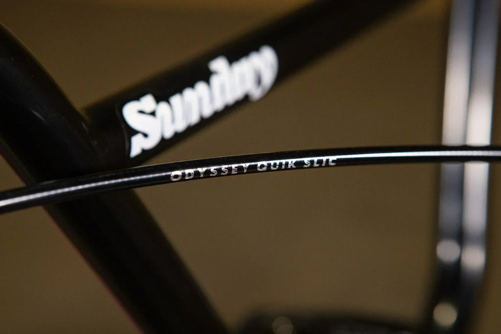 Gros plan du câble de frein Odyssey Quik Slic sur un cadre de vélo BMX Sunday noir