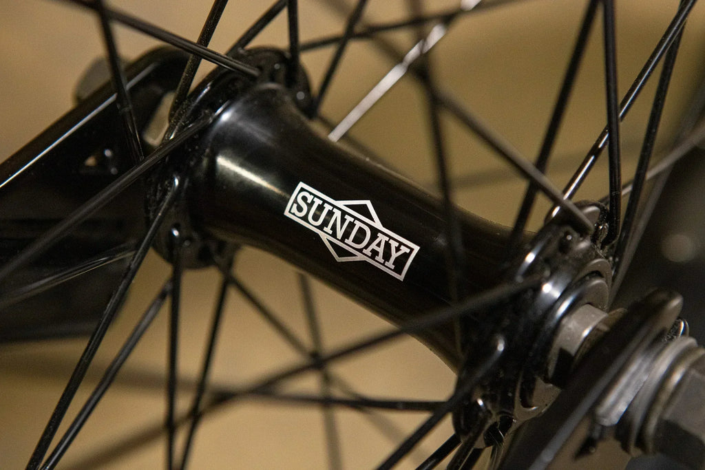 Gros plan d'un moyeu de roue BMX noir avec le logo Sunday