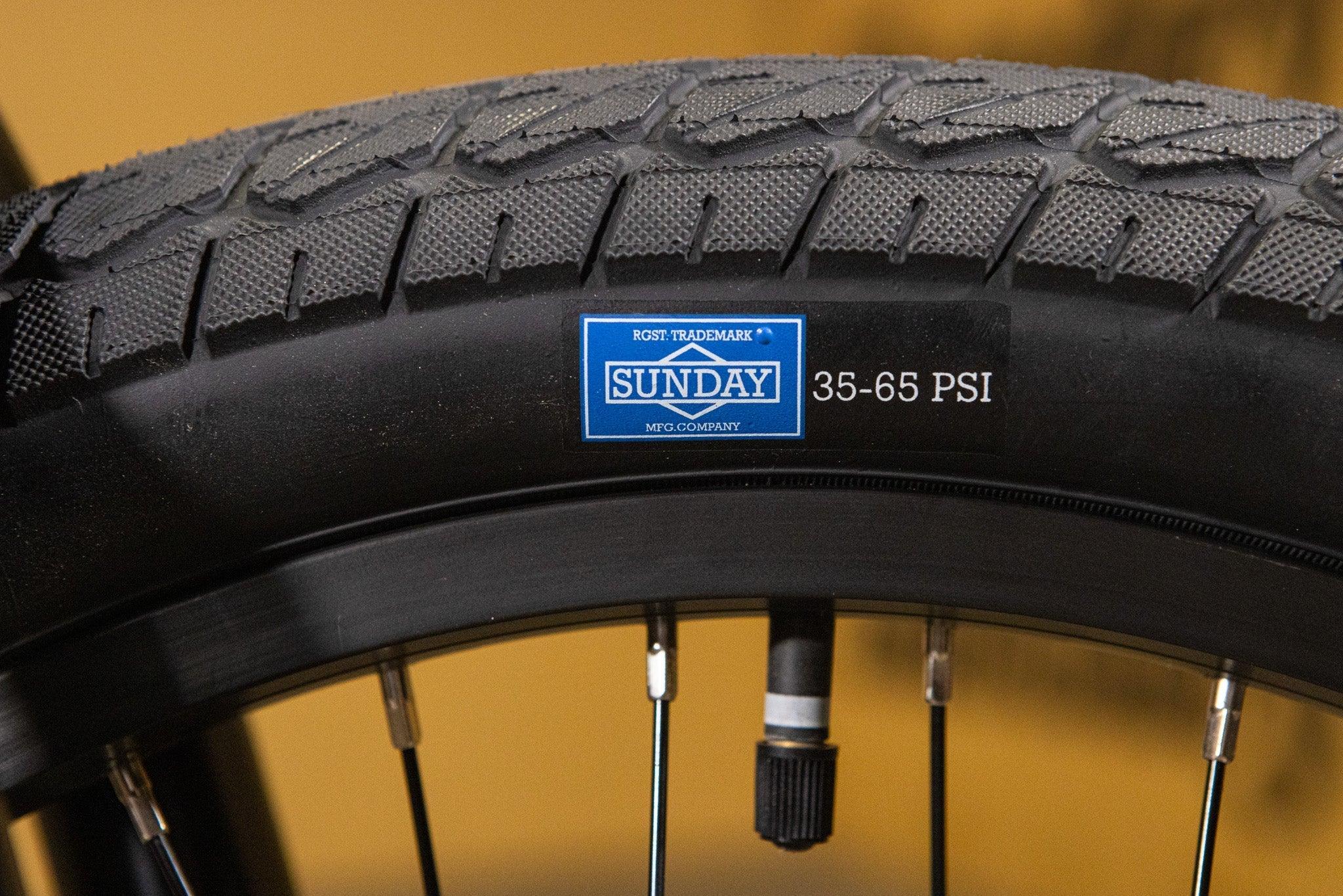 Gros plan d'un pneu de vélo BMX Sunday avec indication de pression 35-65 PSI.