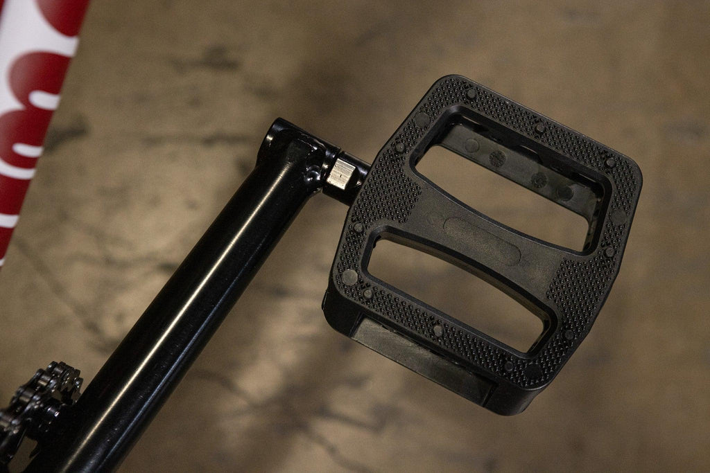 Gros plan d'une pédale de vélo BMX noire avec surface antidérapante