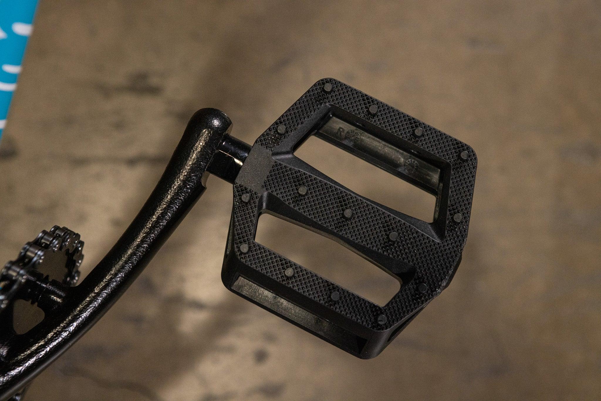 Gros plan d'une pédale de vélo BMX noire en nylon avec picots antidérapants.