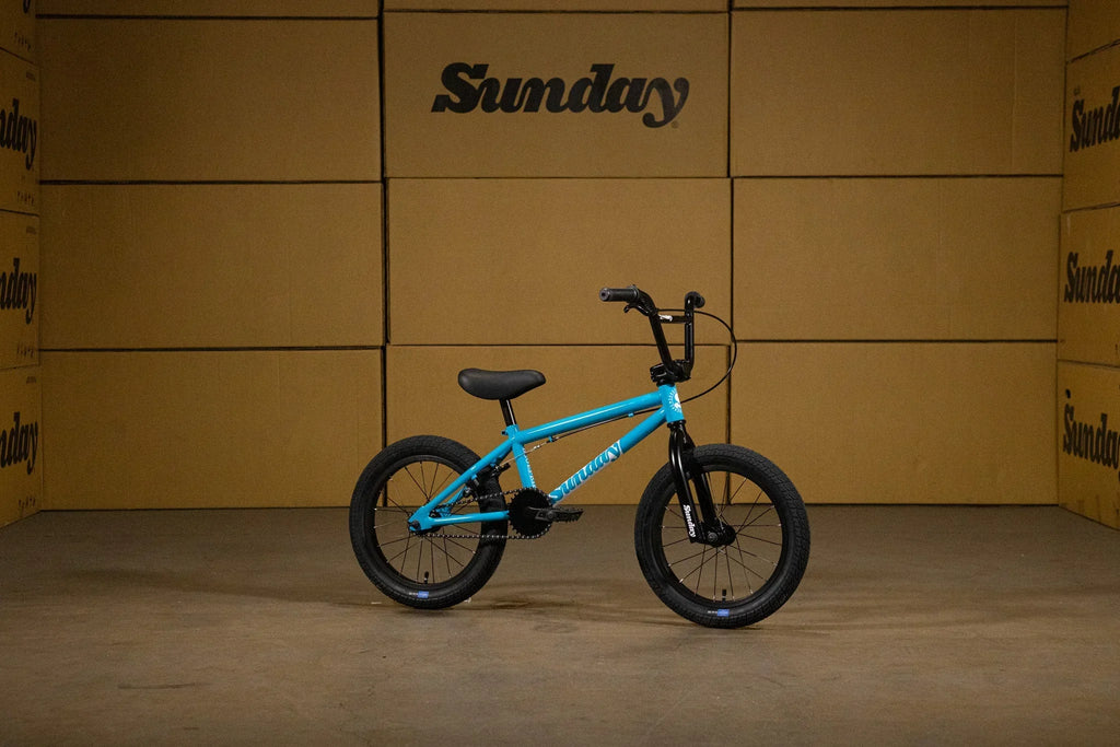 Vélo BMX bleu Sunday posé devant des cartons bruns.