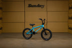 Vélo BMX bleu Sunday posé devant des cartons bruns.