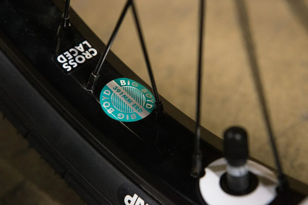 Détail d'une jante de vélo noire avec autocollant technique de diamètre ERD 391mm.