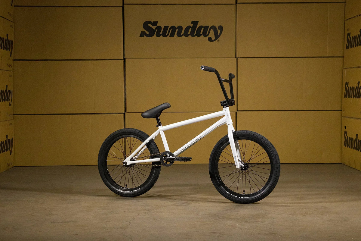 Vélo BMX blanc sur fond de cartons Sunday