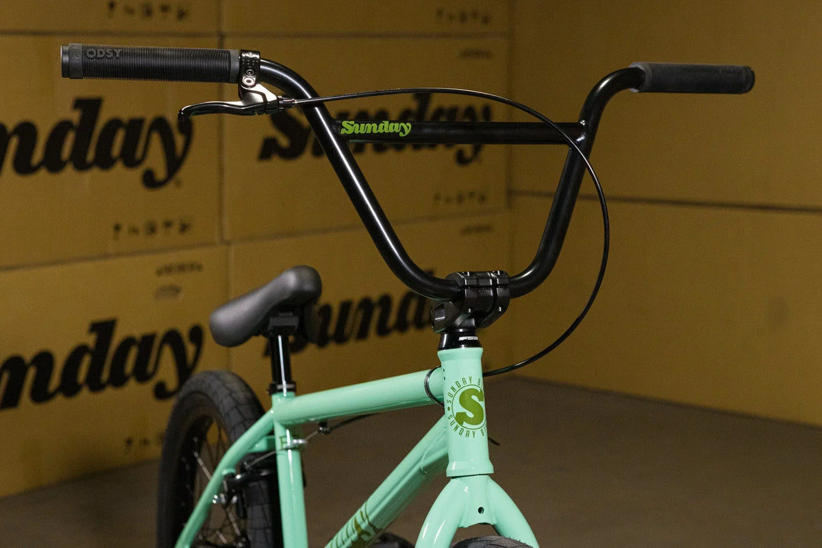Détails du guidon et du cadre d'un vélo BMX de couleur menthe.