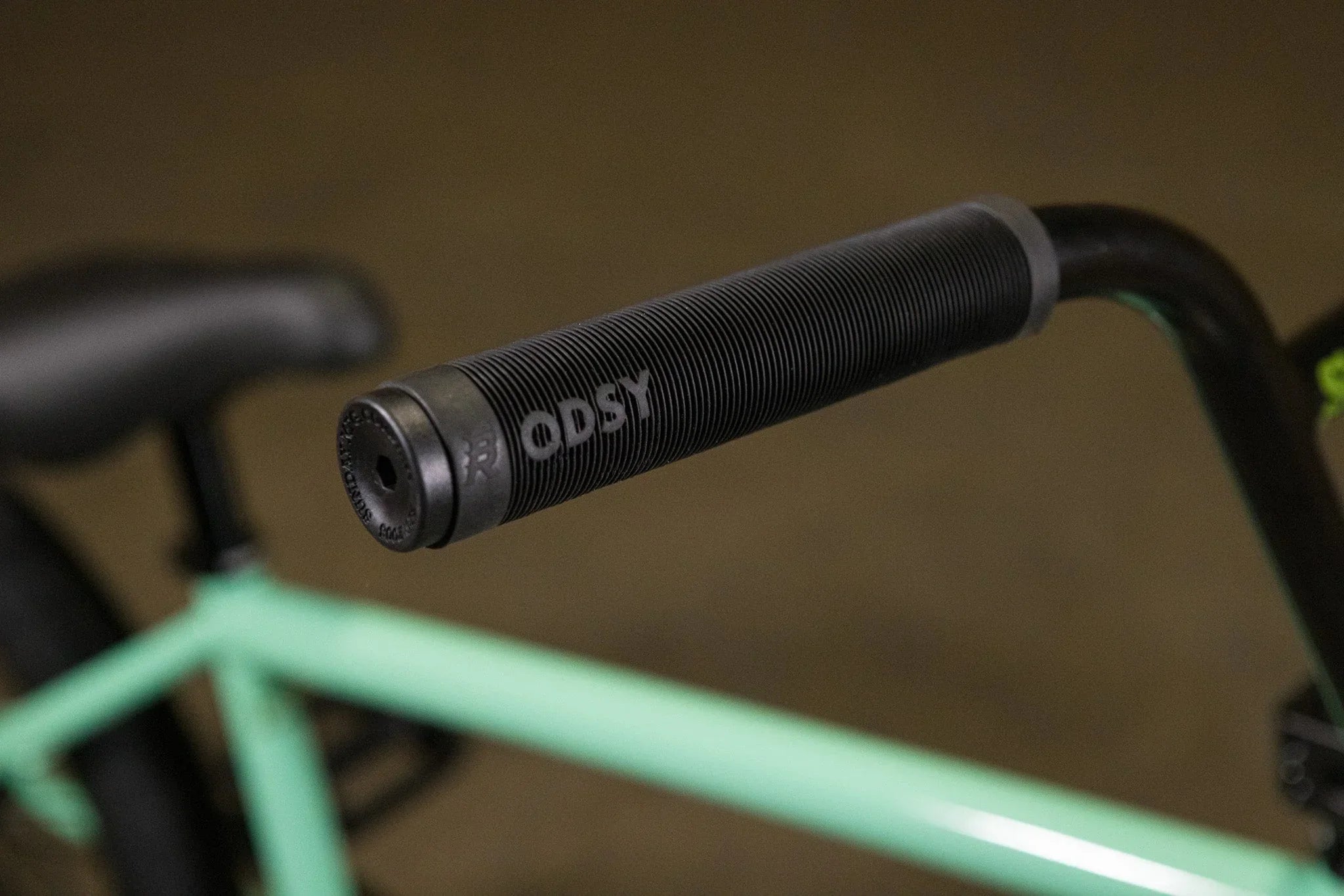Gros plan d'une poignée de guidon BMX noire texturée de marque Odysy
