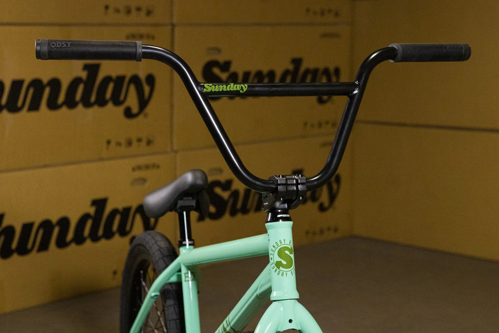 Gros plan du guidon et du cadre vert menthe d'un vélo BMX Sunday