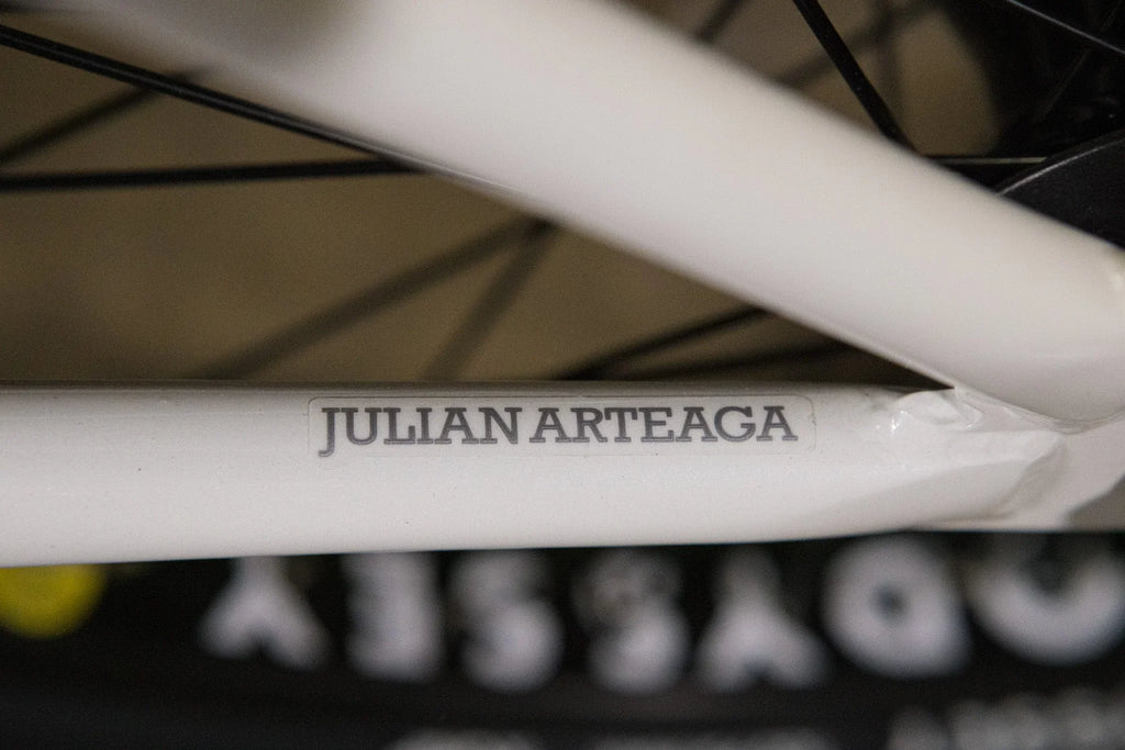 Gros plan d'un cadre de vélo BMX blanc avec l'inscription Julian Arteaga.