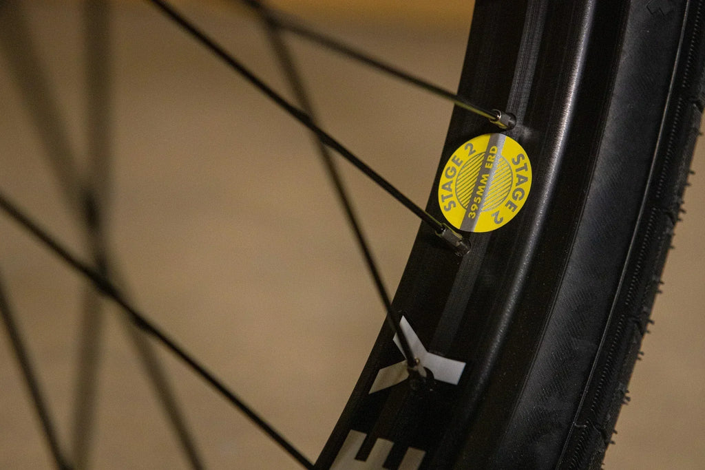 Gros plan d'une jante de vélo BMX avec un autocollant jaune Stage 2 395mm ERD.