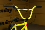 Gros plan du guidon jaune fluo d'un vélo BMX Sunday avec poignées noires
