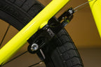 Gros plan d'un frein Spring Field noir sur un cadre de BMX jaune fluo