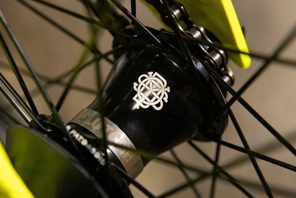 Gros plan sur le moyeu arrière noir d'un vélo BMX avec un logo blanc distinctif