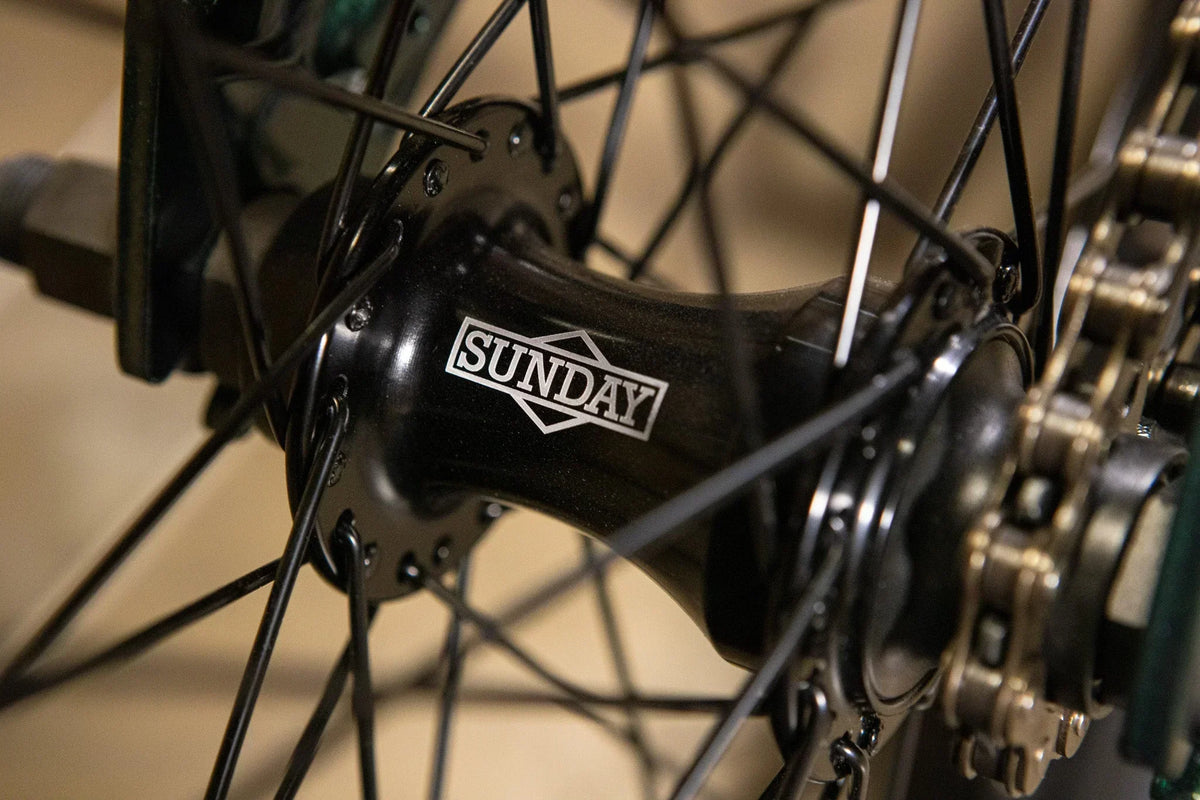 Gros plan d'un moyeu de roue BMX noir avec le logo Sunday.