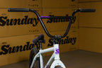 Gros plan d'un guidon noir de vélo BMX Sunday sur cadre blanc.