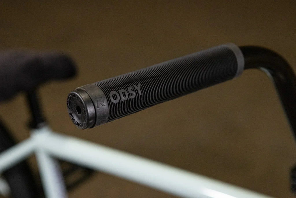 Gros plan d'une poignée de guidon BMX noire texturée de marque Odyssey