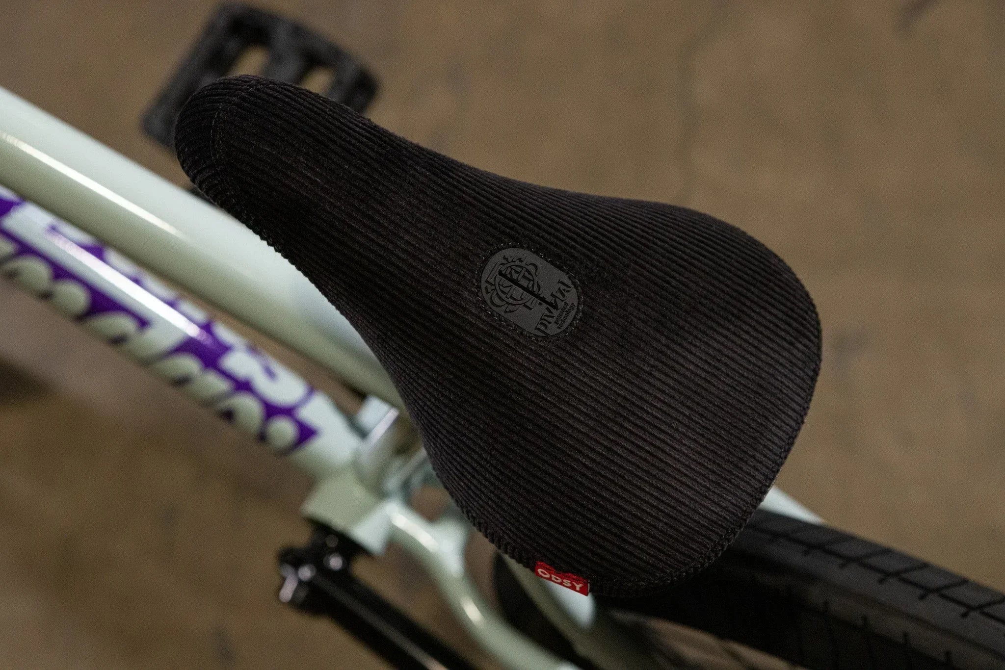 Gros plan d'une selle de vélo BMX noire texturée avec logo Odyssey